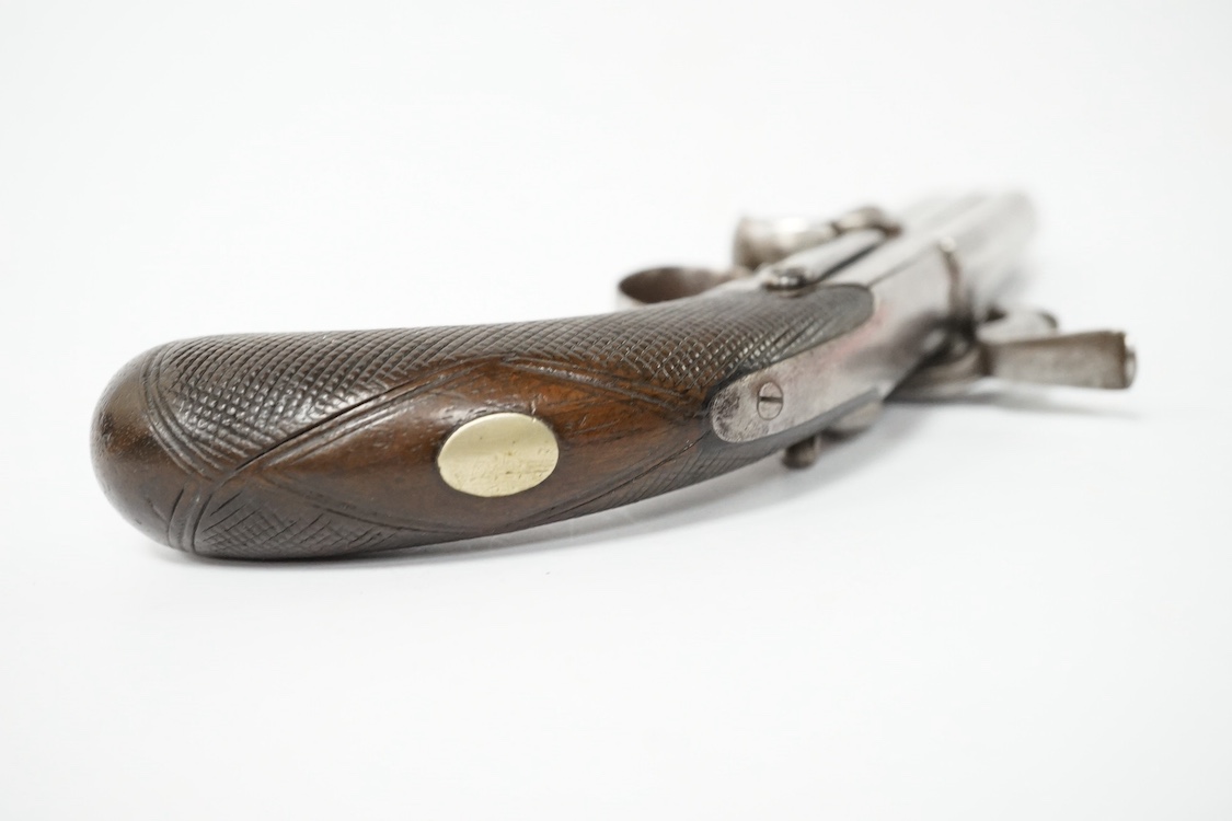 A two shot 34 bore turnover percussion travelling pistol, barrel with London and Birmingham proof marks, 9.5 cm, unsigned, sliding thumb safety catch, boxlock side hammer action, rounded chequered walnut grip with oval n